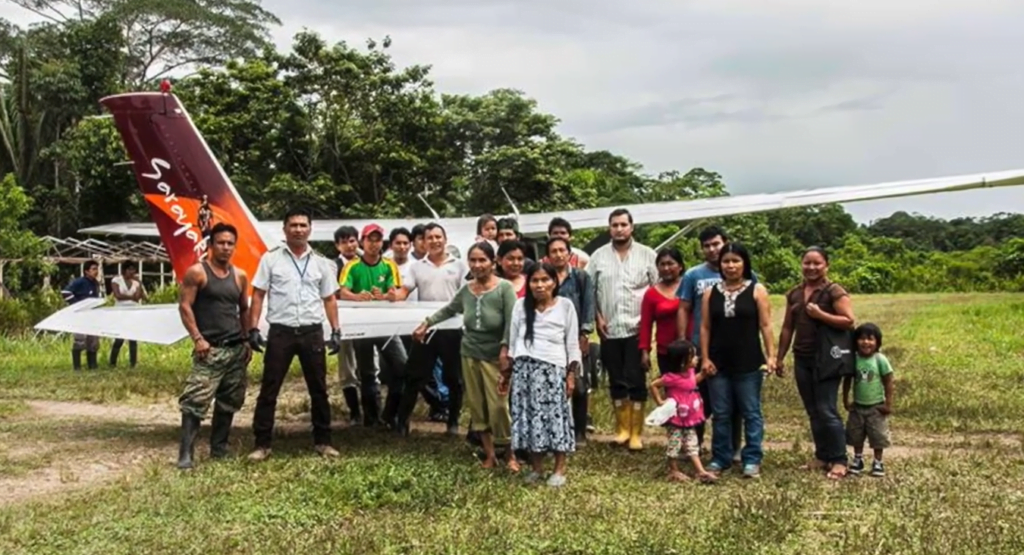 Personas del Pueblo de Sarayaku en Pastaza, amazonía de Ecuador junto a una de sus avionetas para transporte aéreo